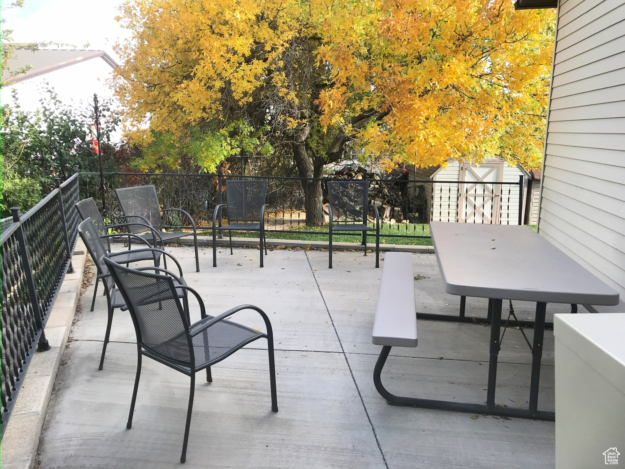 View of patio / terrace featuring an outbuilding, a shed, and fence