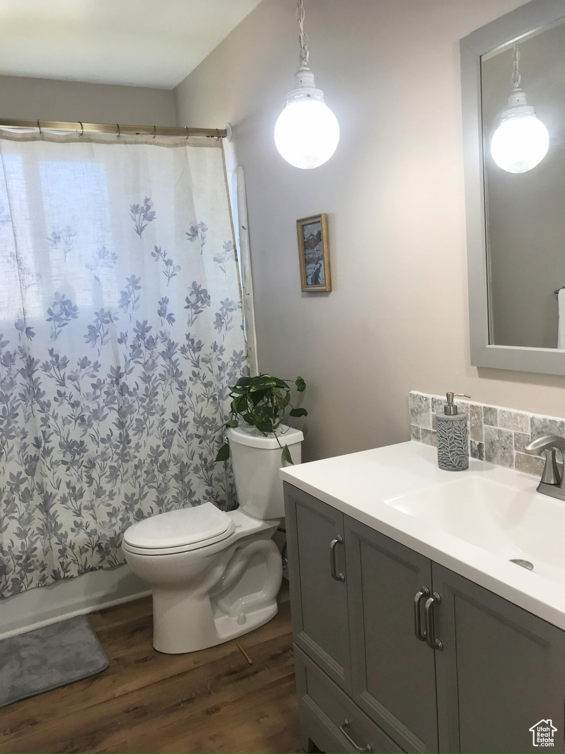 Full bath featuring toilet, tasteful backsplash, wood finished floors, and vanity