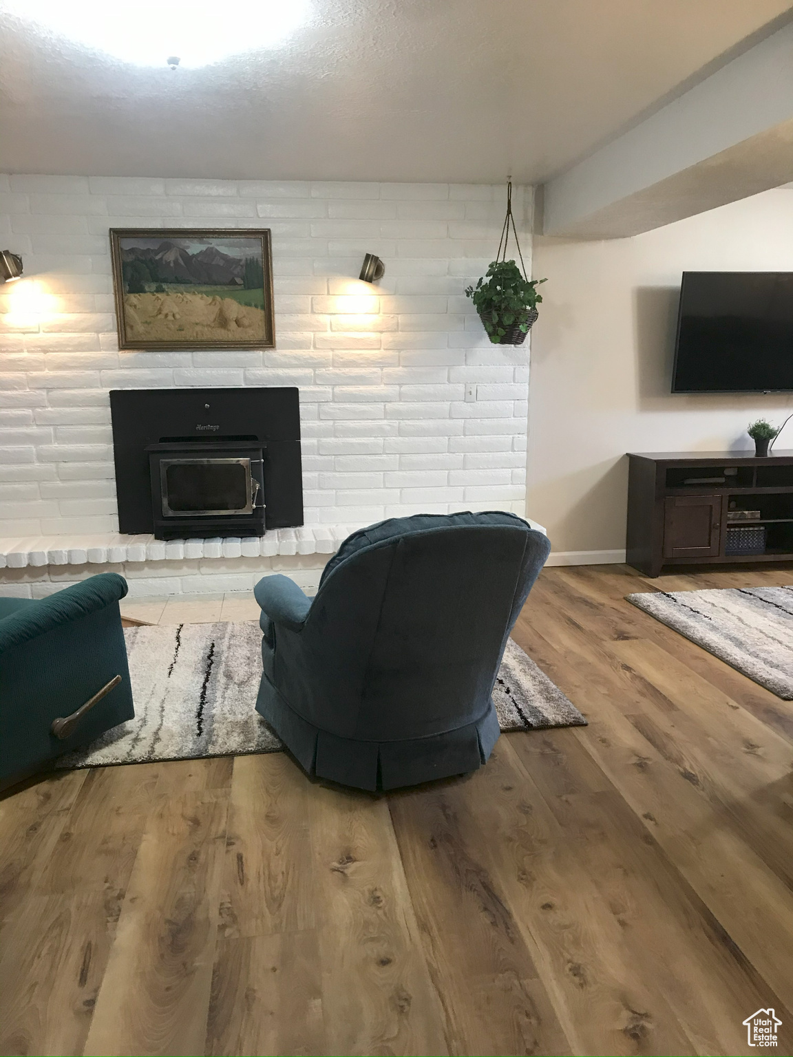 Living area with a fireplace, wood finished floors, and baseboards