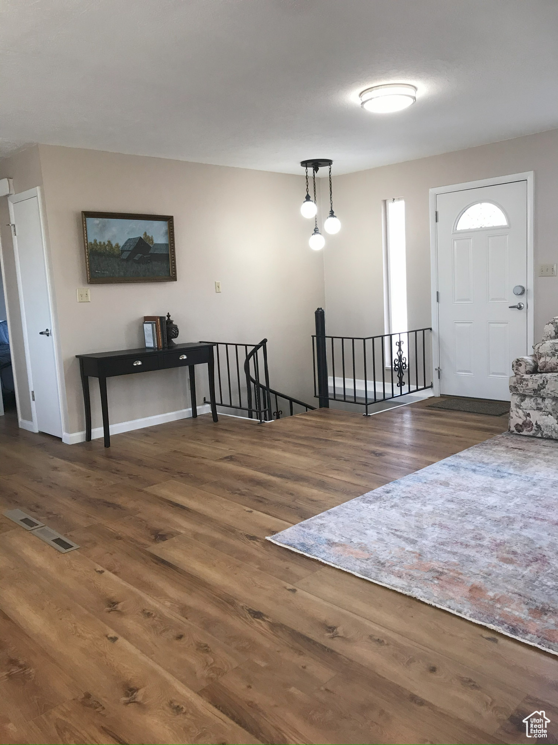 Foyer with dark wood-style floors, visible vents, and baseboards