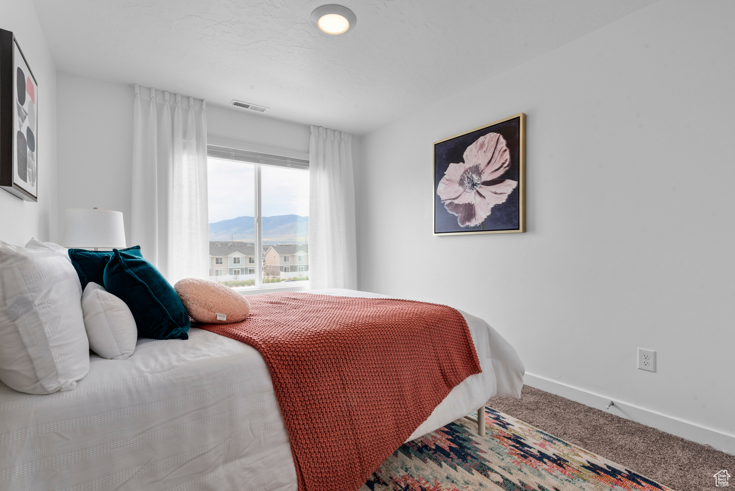 Carpeted bedroom featuring visible vents, a mountain view, and baseboards