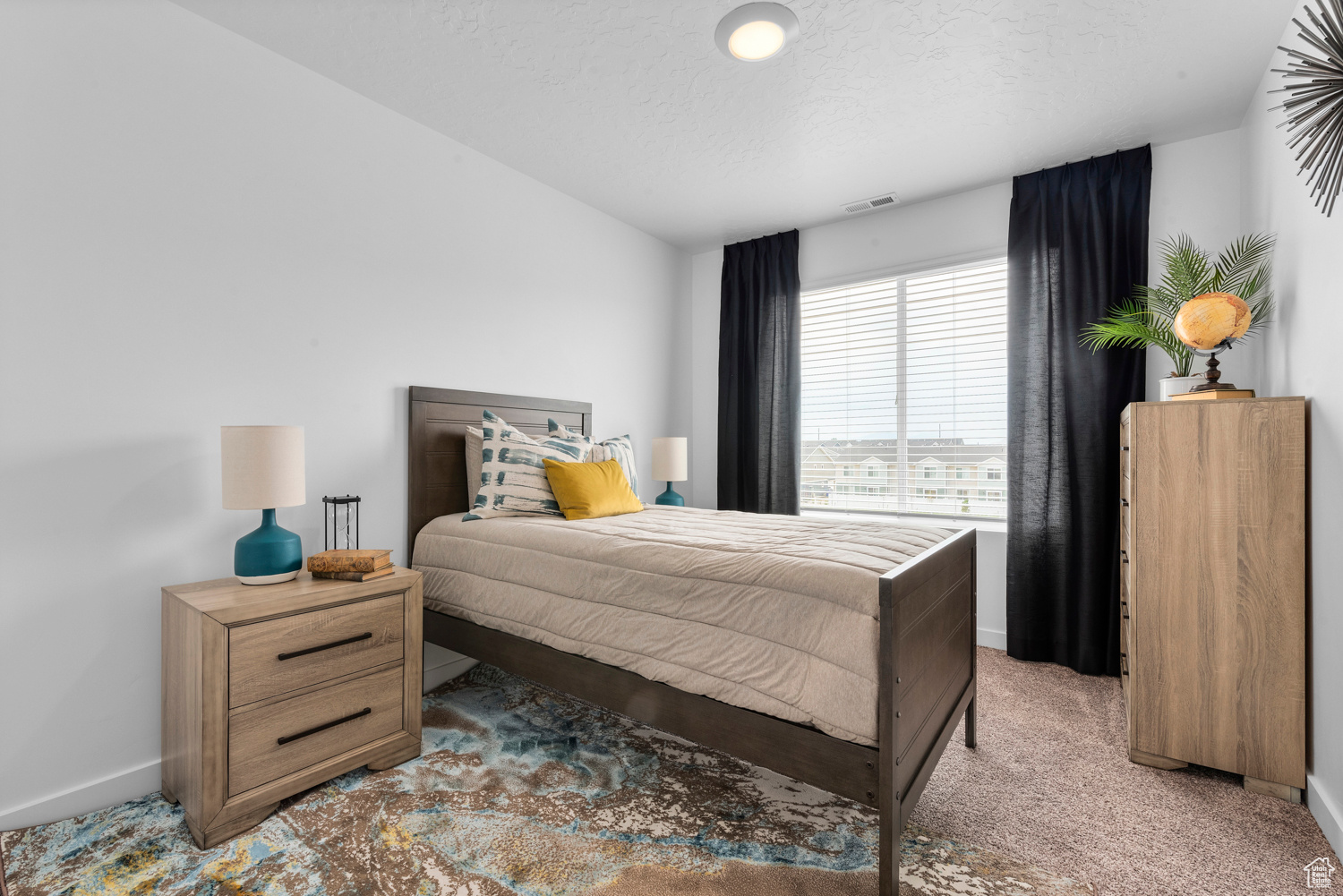 Carpeted bedroom featuring baseboards, visible vents, and a textured ceiling