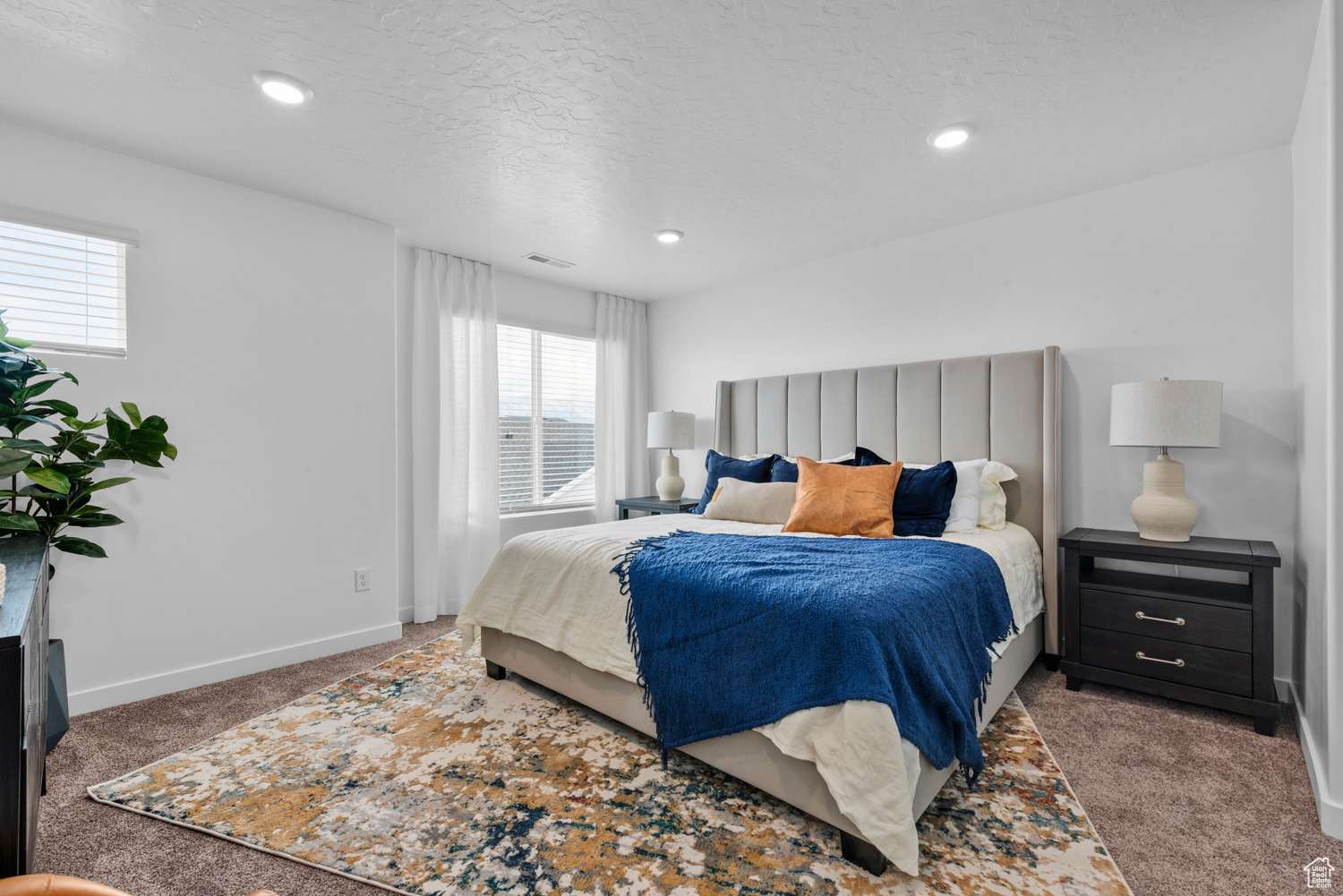 Bedroom featuring a textured ceiling, recessed lighting, visible vents, baseboards, and dark carpet