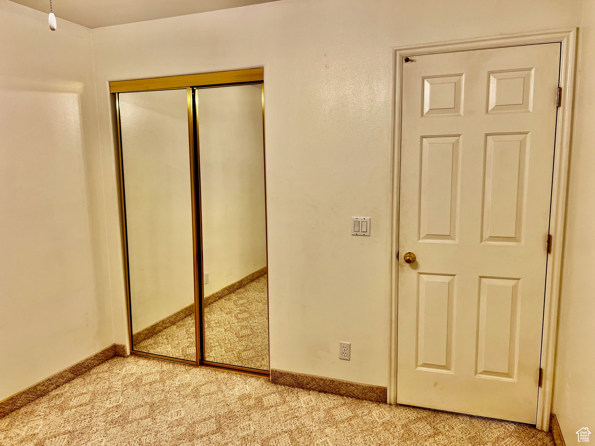 Unfurnished bedroom with baseboards, a closet, and light colored carpet