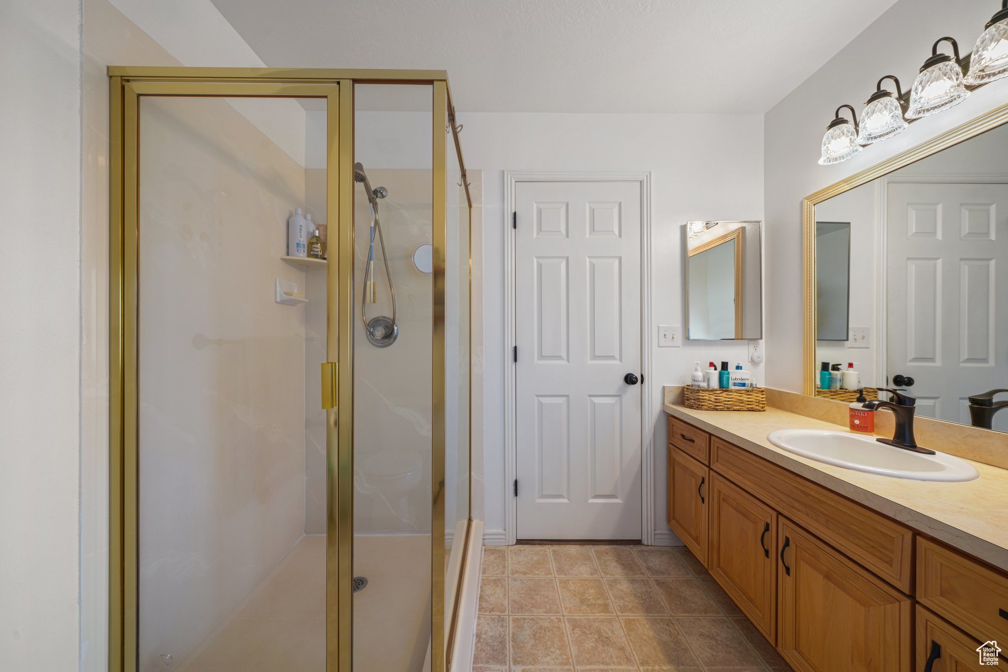 Full bath with a shower stall and vanity