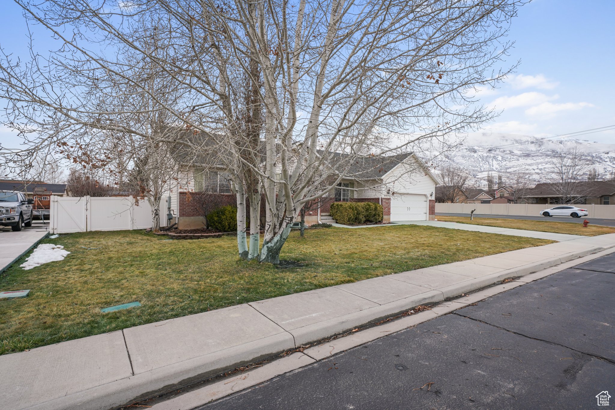 View of front facade with a front yard, fence, a garage, a residential view, and driveway