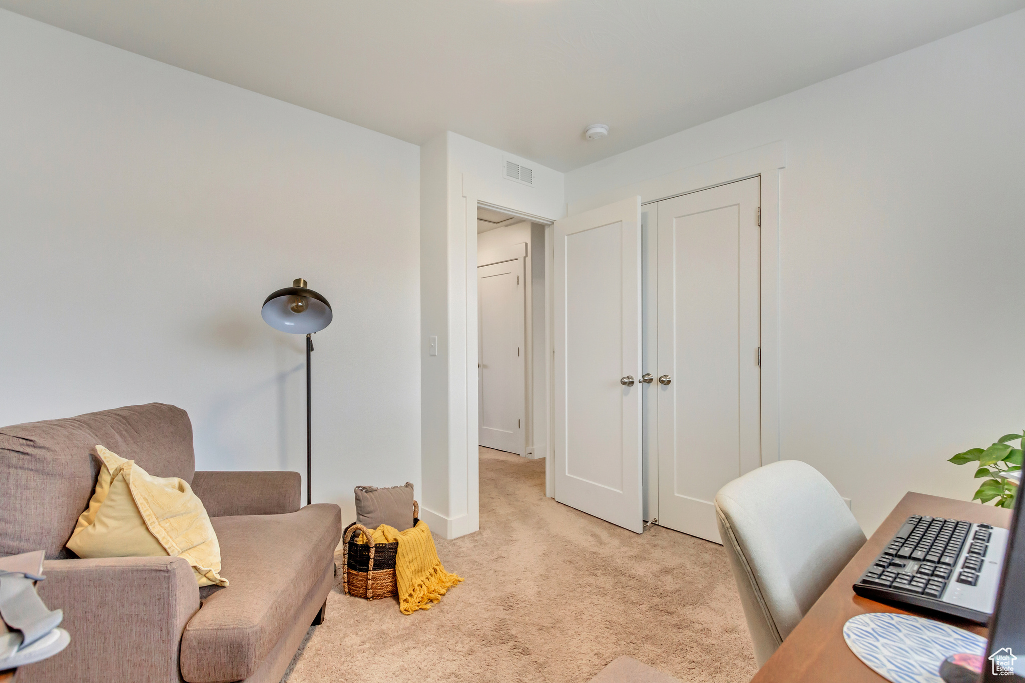 Office area featuring light colored carpet, visible vents, and baseboards