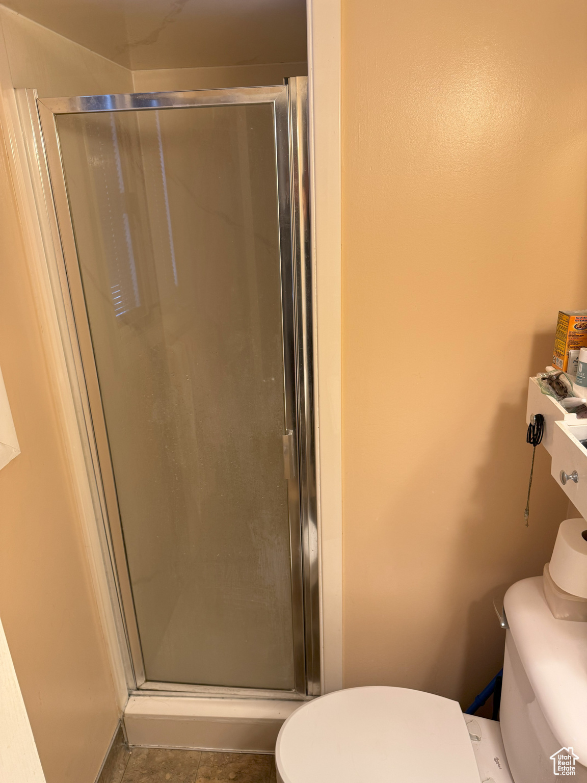 Bathroom with a shower stall and toilet