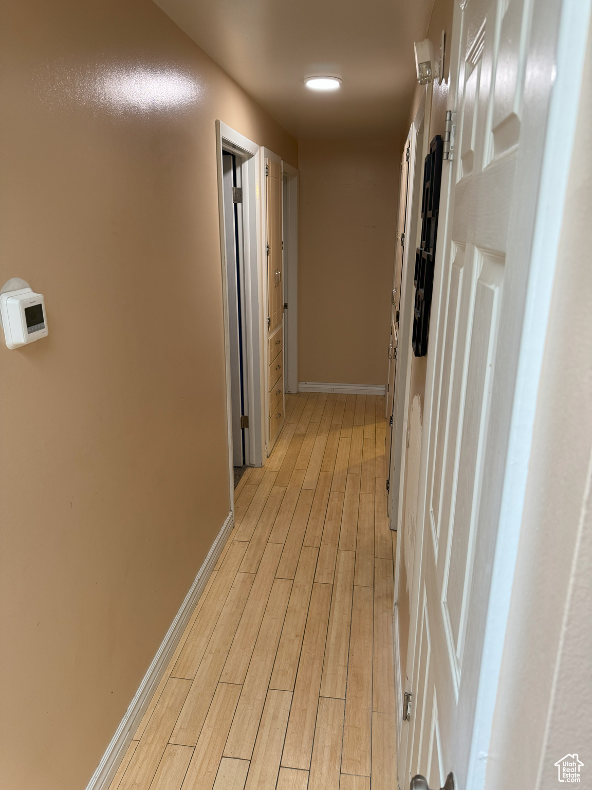 Hall with light wood-type flooring and baseboards