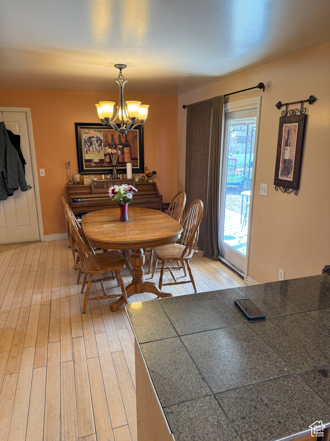 Dining space with light wood-style flooring, a chandelier, and baseboards