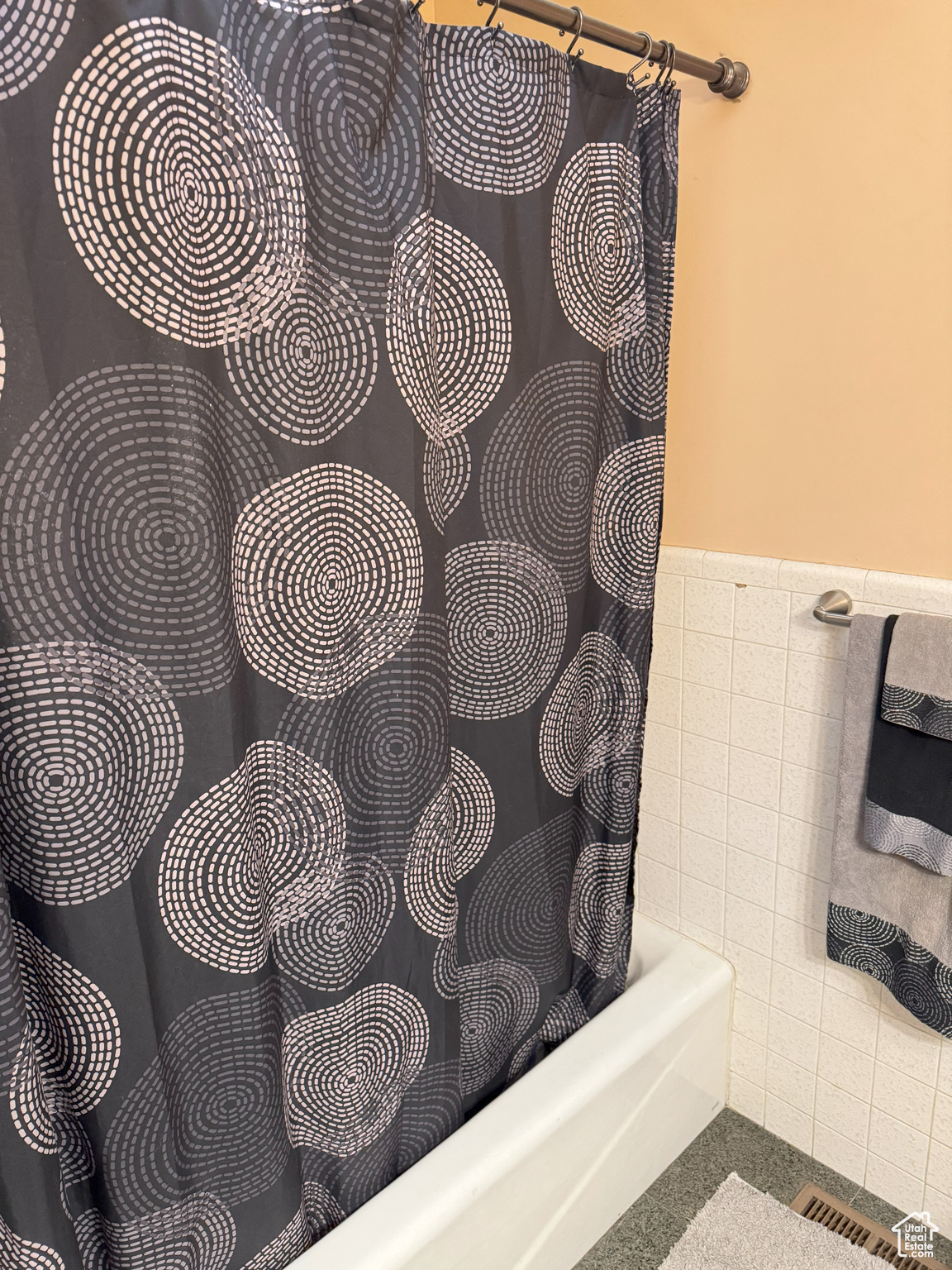 Room details with a wainscoted wall and shower / bath combo with shower curtain