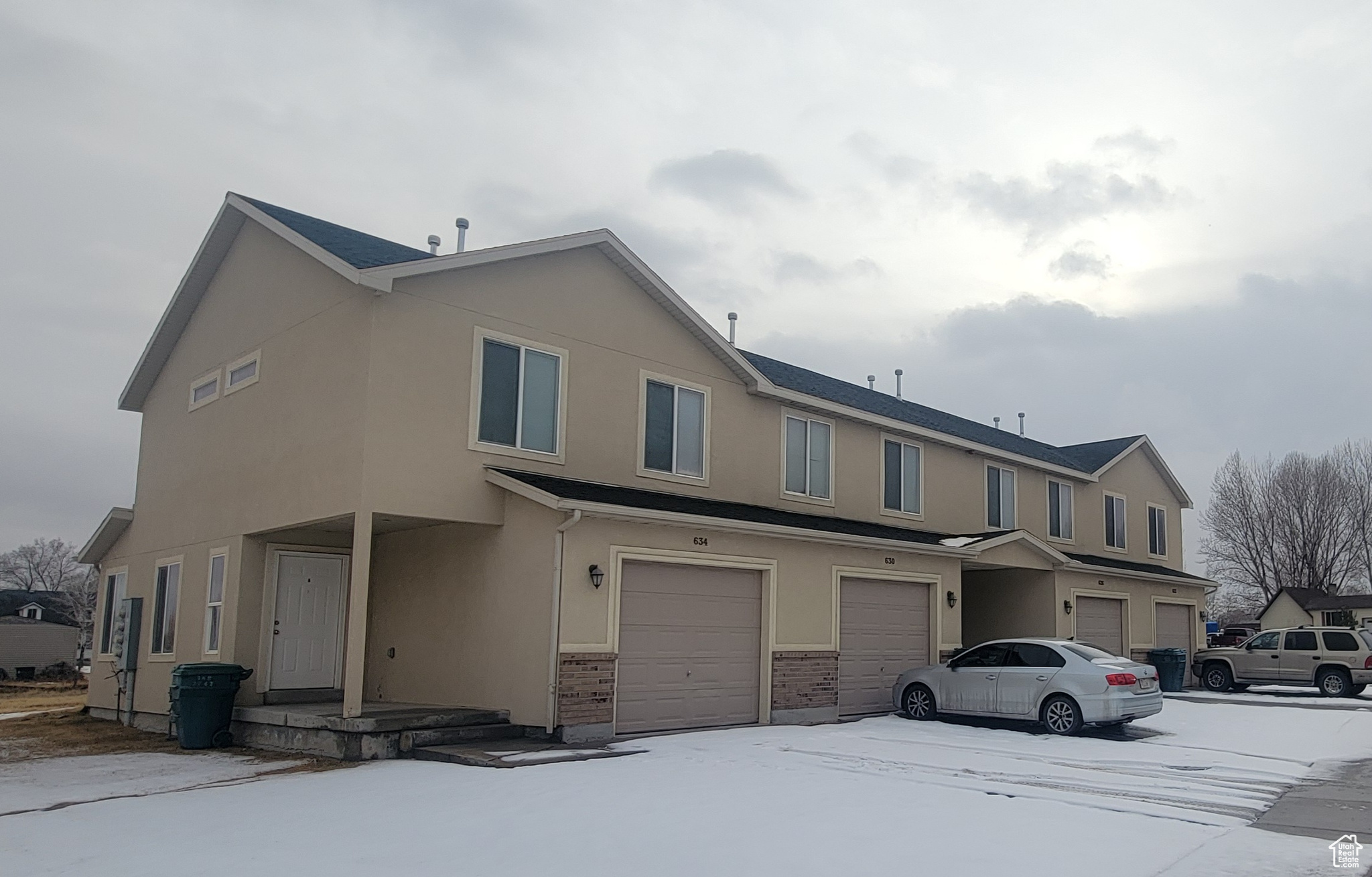 Townhome / multi-family property featuring a garage and stucco siding