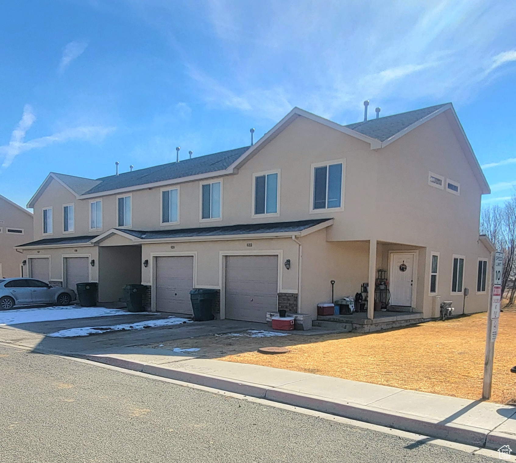 Multi unit property with an attached garage, concrete driveway, and stucco siding