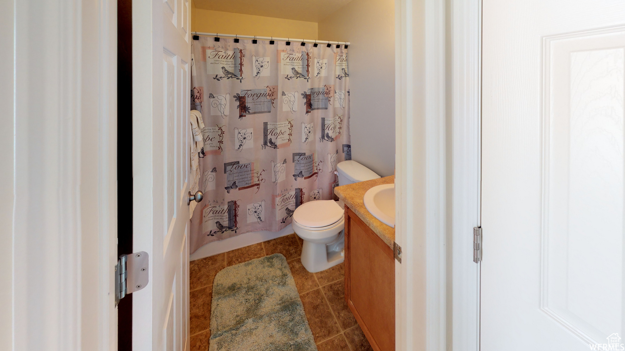 Bathroom with vanity, toilet, and tile patterned floors