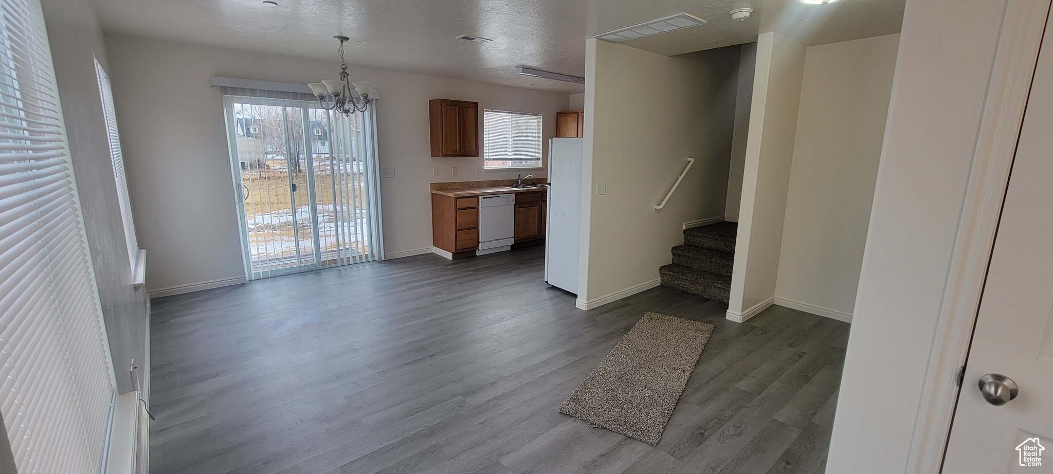 Interior space featuring visible vents, an inviting chandelier, light wood-style floors, baseboards, and stairs