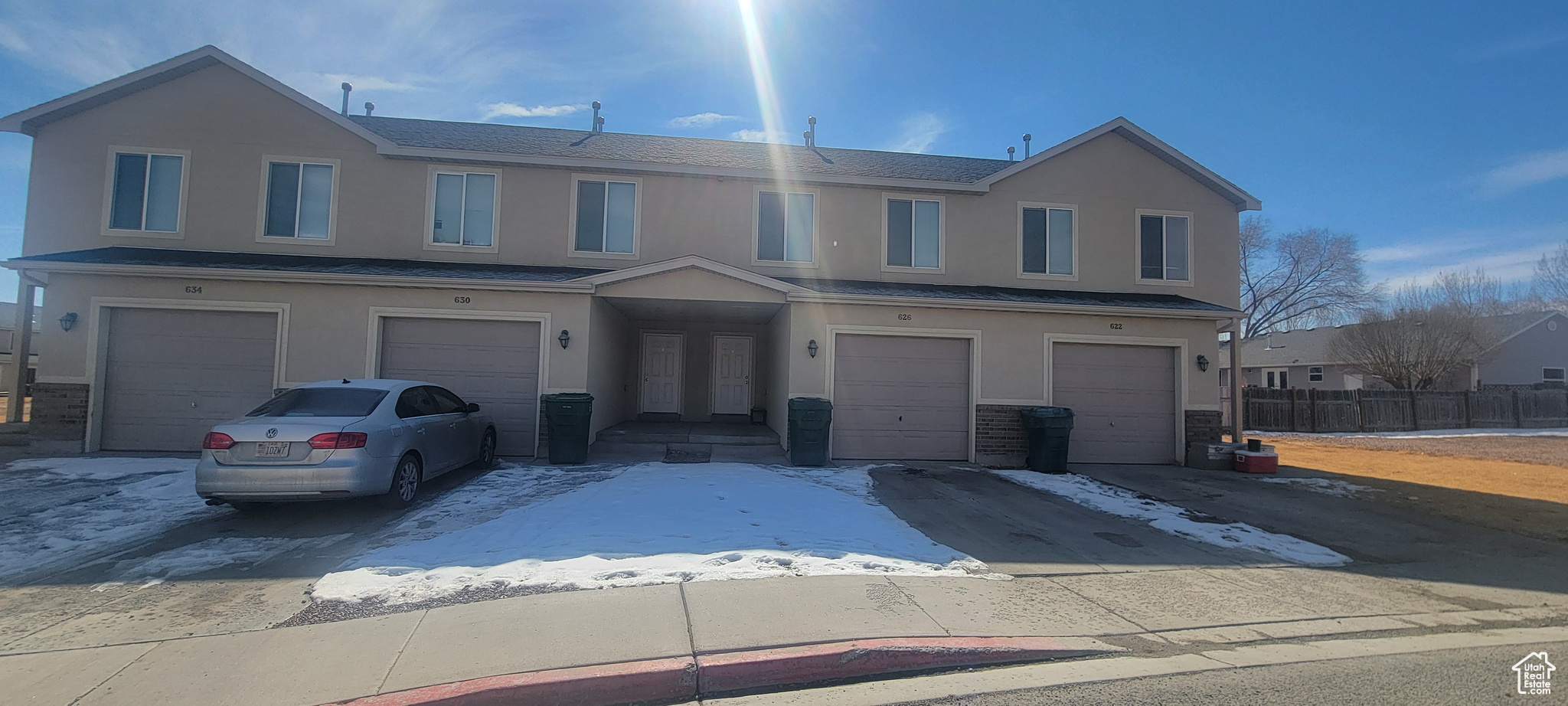 View of property featuring an attached garage and stucco siding