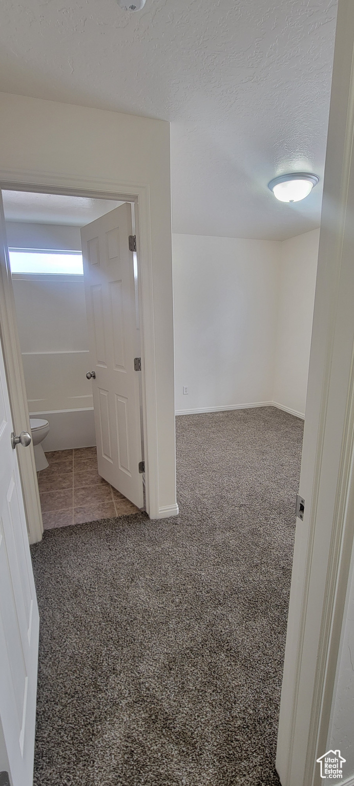 Interior space with a textured ceiling and baseboards