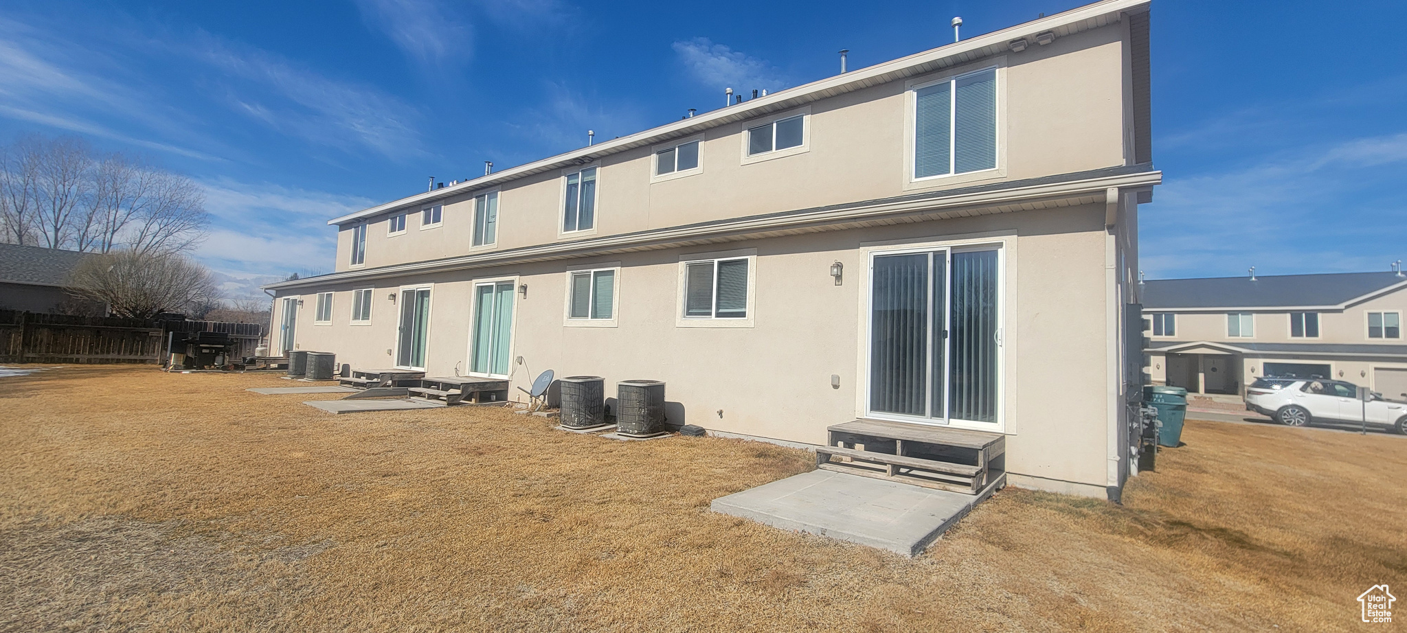 Back of house with entry steps, central AC, fence, and stucco siding