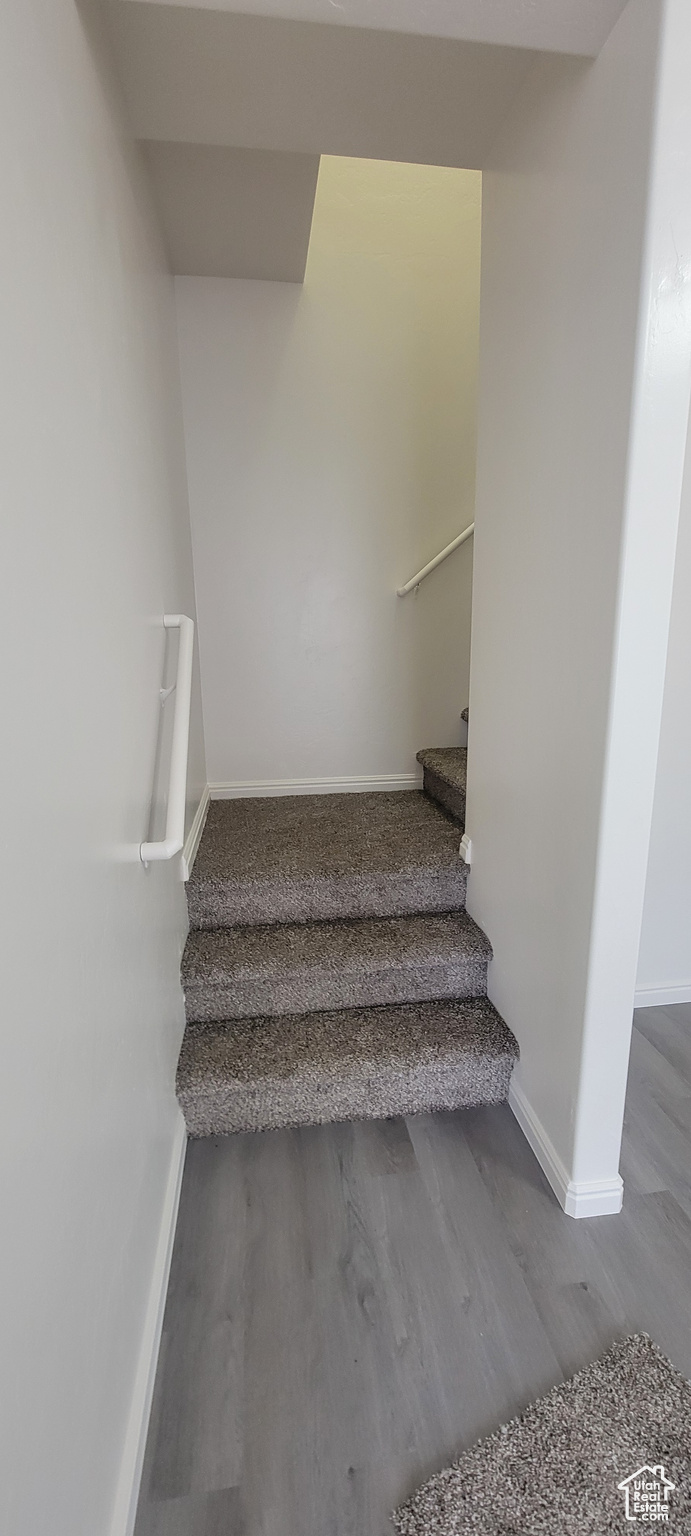 Staircase with baseboards and wood finished floors