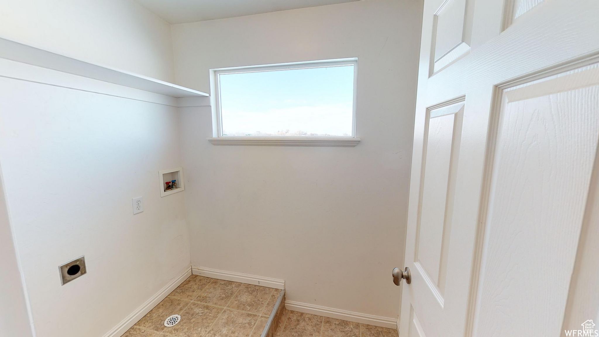 Laundry room featuring light tile patterned floors, hookup for an electric dryer, laundry area, washer hookup, and baseboards