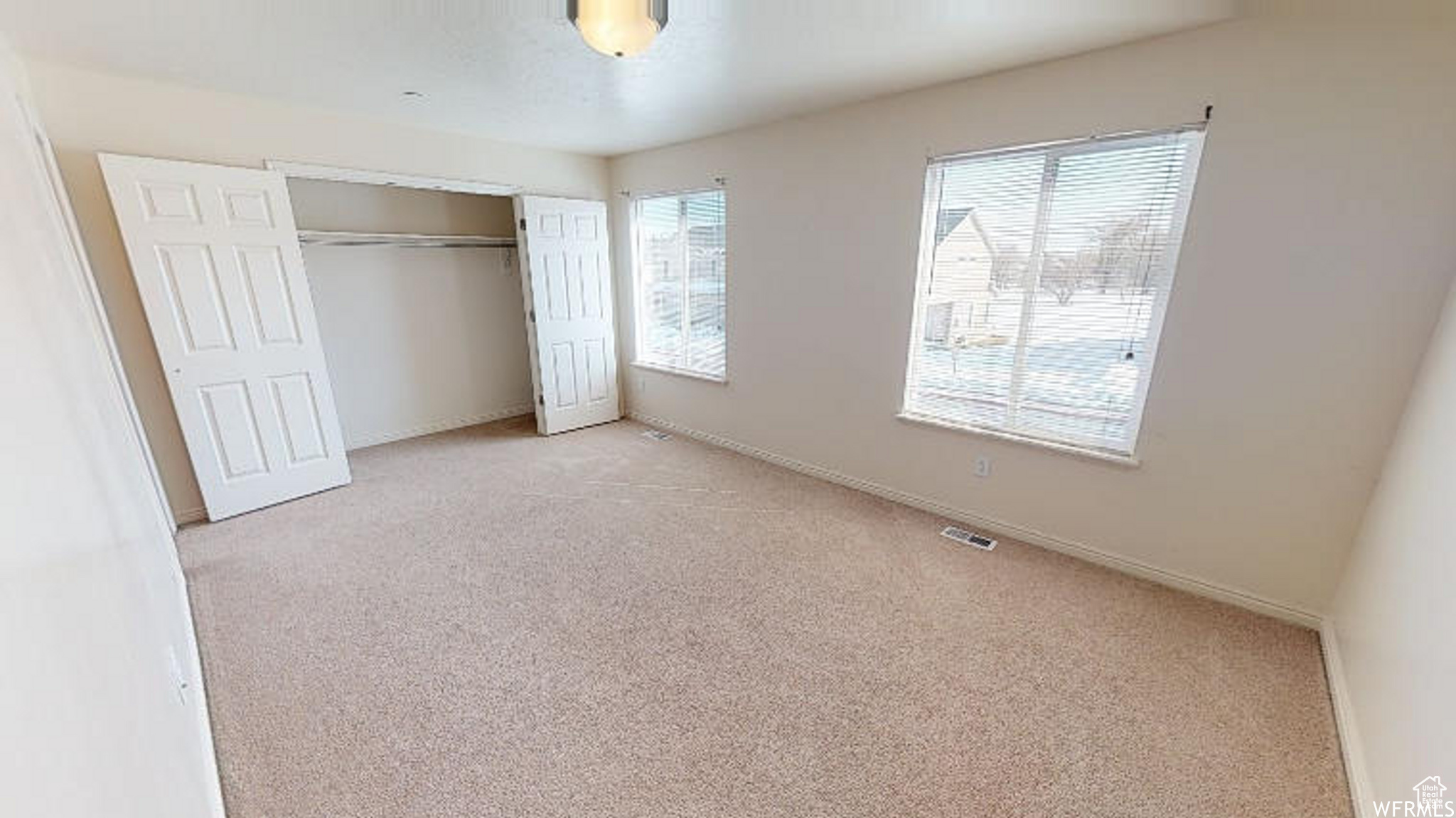 Unfurnished bedroom featuring baseboards, a closet, visible vents, and light colored carpet