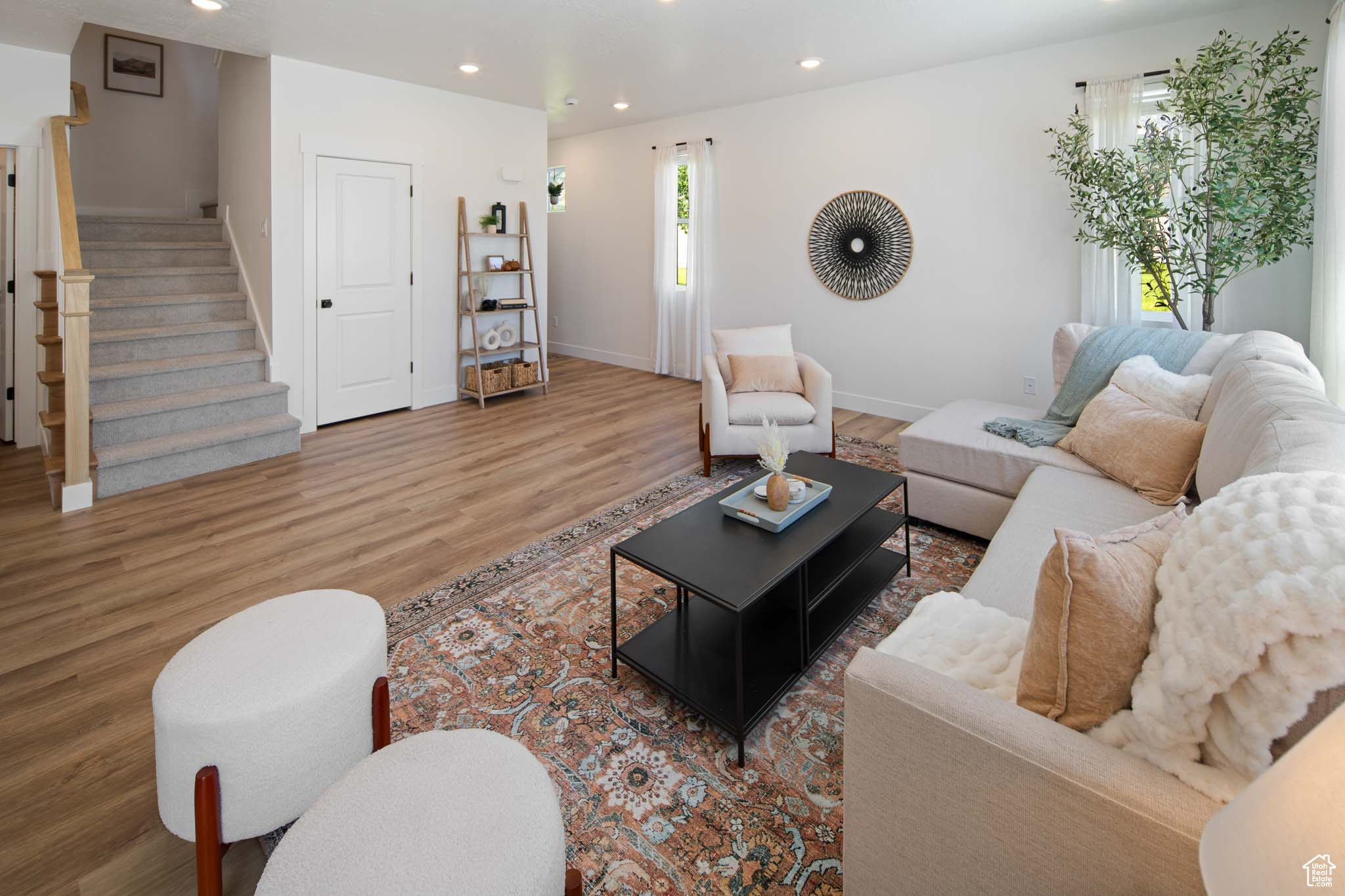 Living room with recessed lighting, wood finished floors, baseboards, and stairs