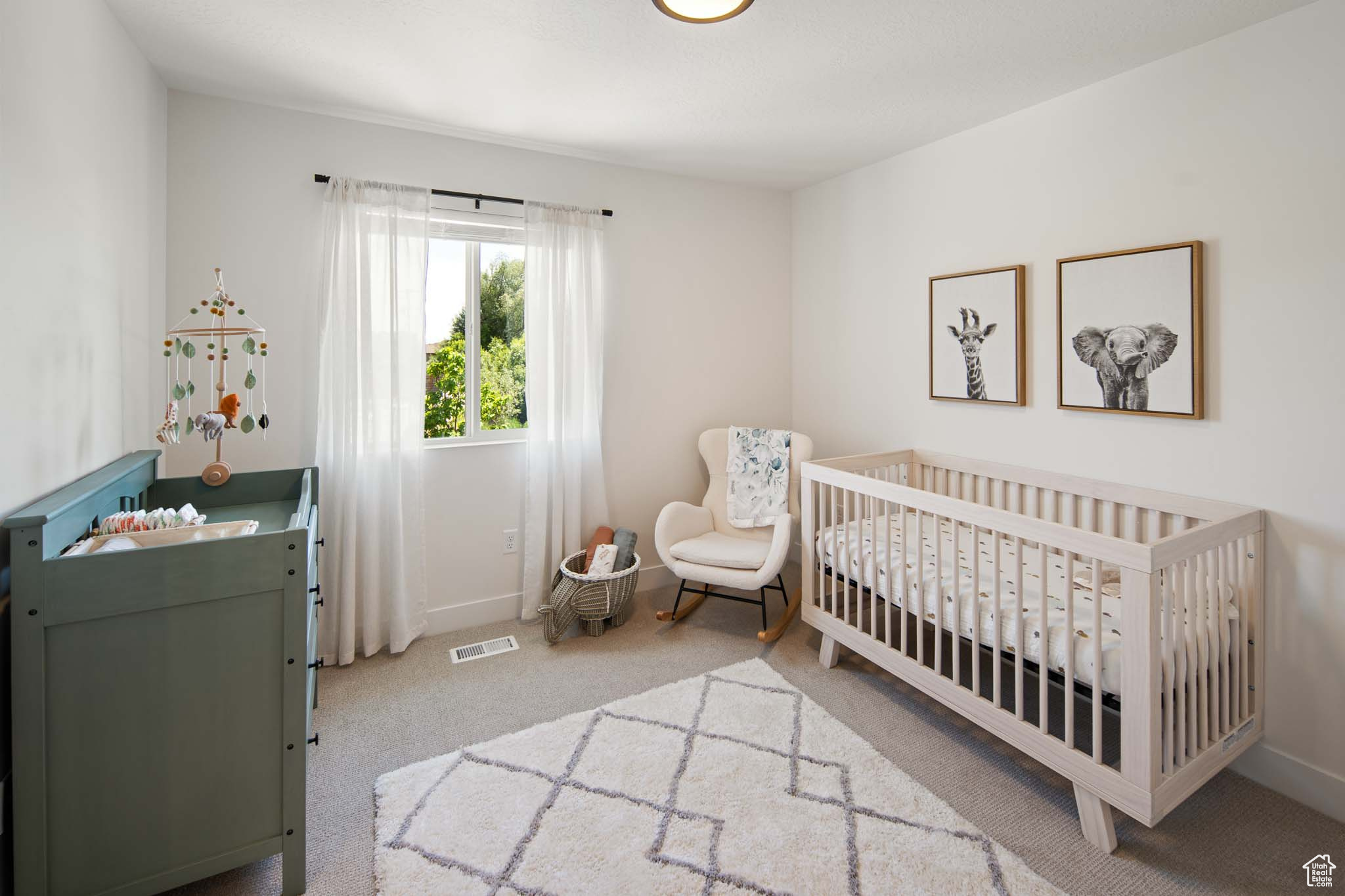 Bedroom with carpet floors, a nursery area, baseboards, and visible vents