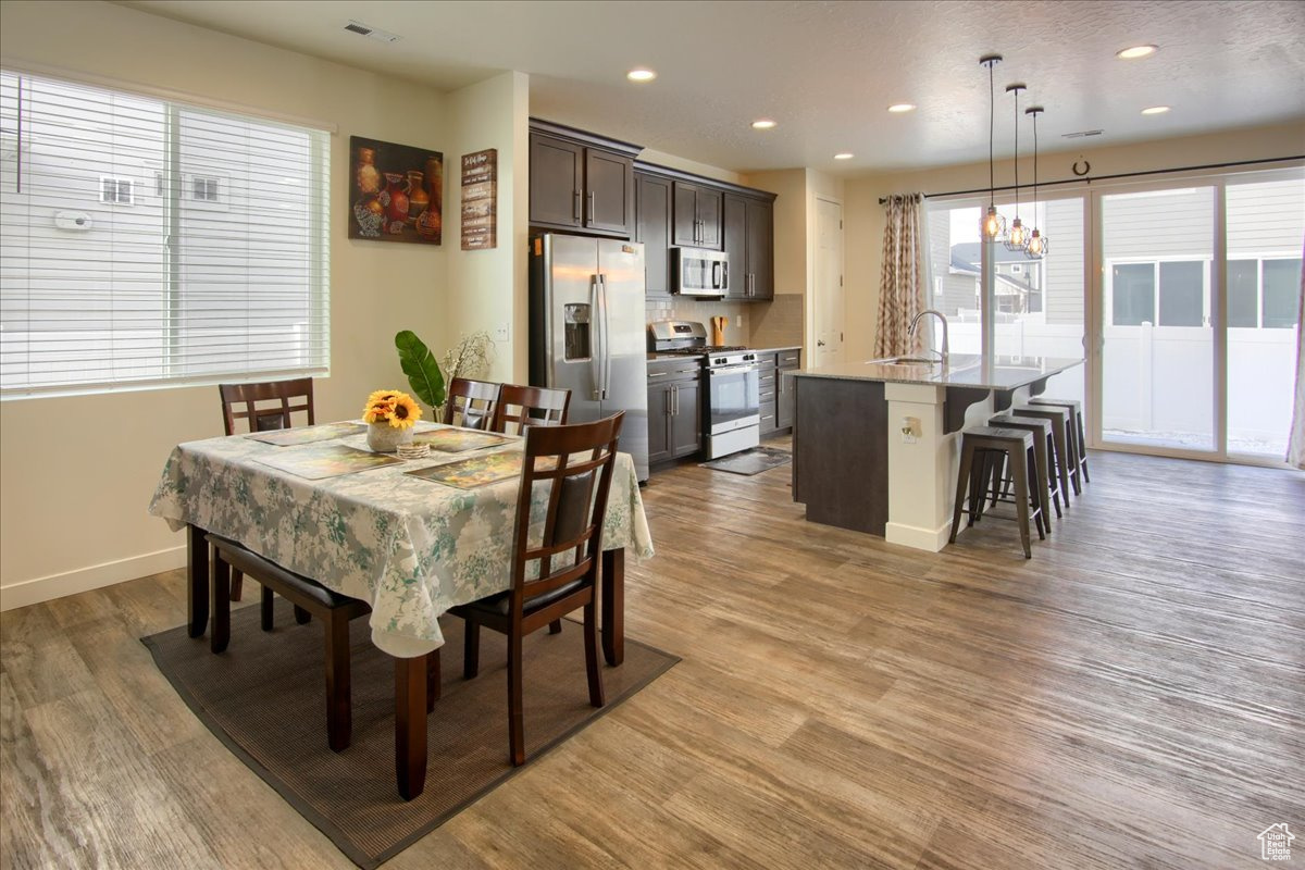Dining space featuring baseboards, light wood-type flooring, visible vents, and recessed lighting