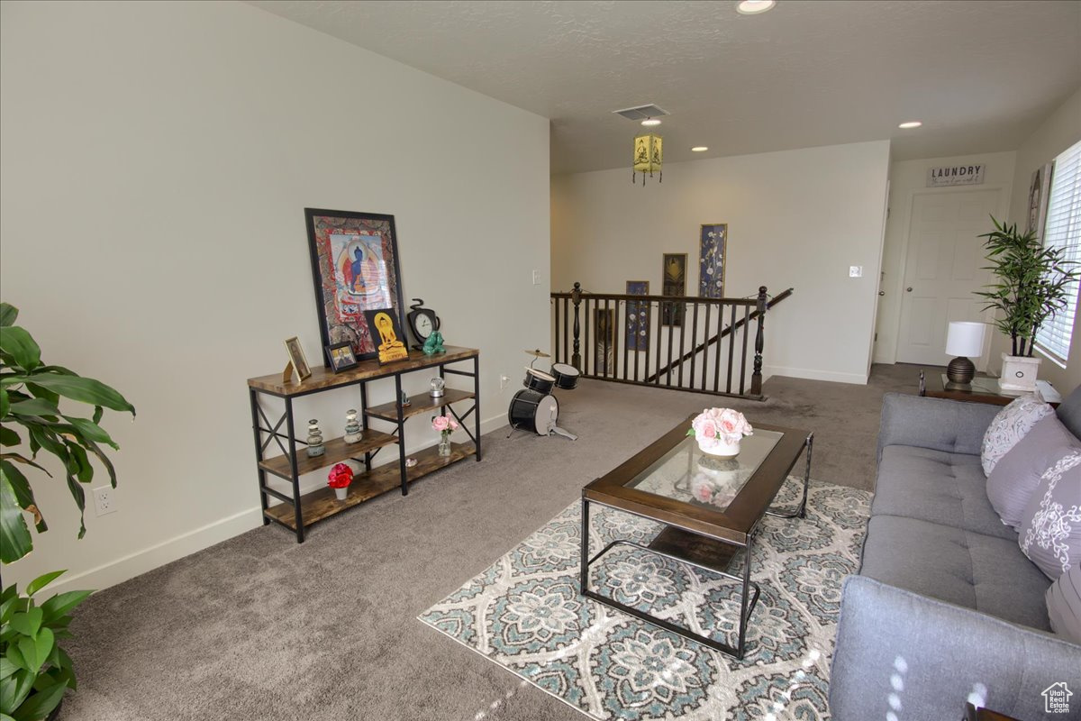 Living area featuring carpet, visible vents, baseboards, and recessed lighting