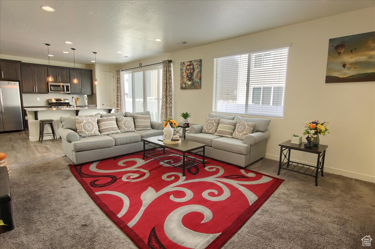 Living room featuring dark colored carpet, recessed lighting, and baseboards