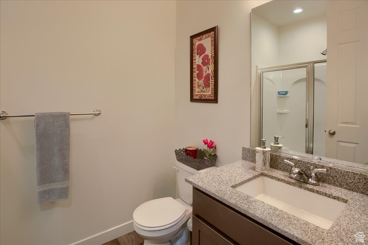 Full bathroom with a stall shower, baseboards, vanity, and toilet