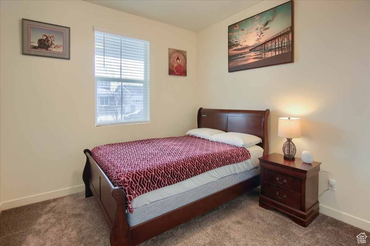 Bedroom with light carpet and baseboards