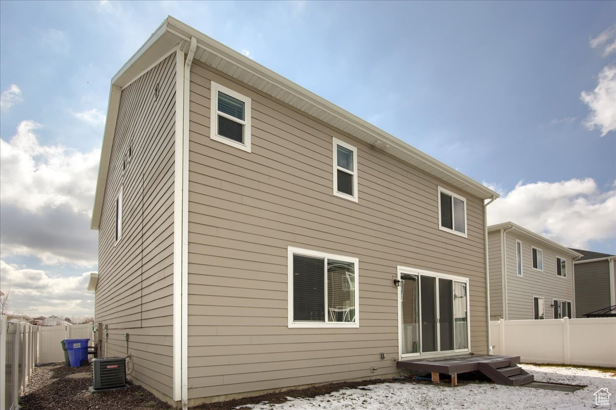 Back of house featuring central AC and a fenced backyard