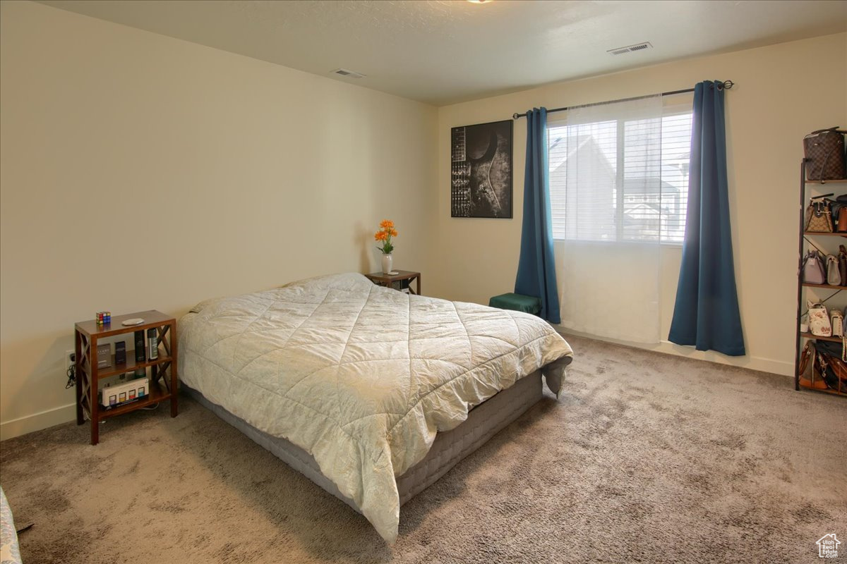 Bedroom with carpet, visible vents, and baseboards