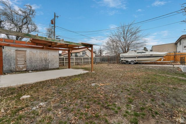 View of yard with a patio and fence