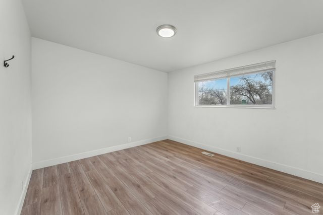 Unfurnished room with baseboards and light wood-style floors