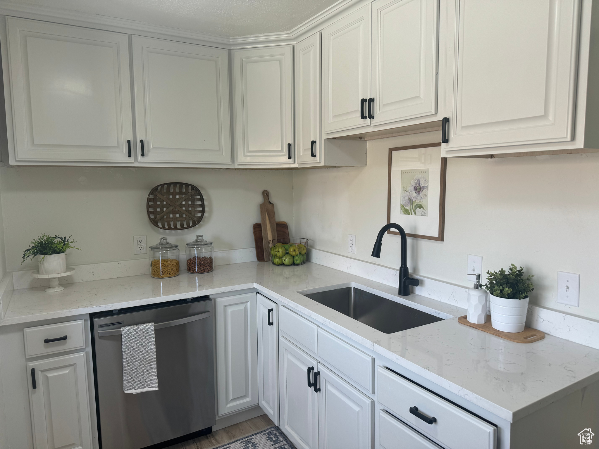 Kitchen with a sink, white cabinets, and stainless steel dishwasher