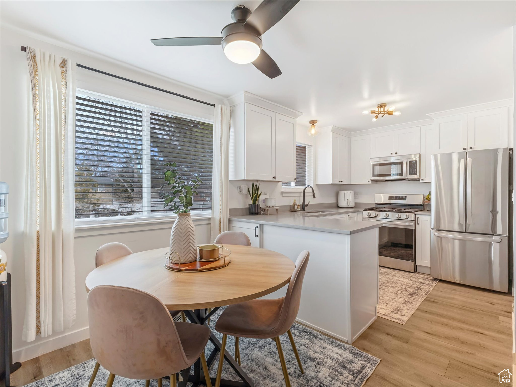 Kitchen featuring a sink, white cabinets, a wealth of natural light, and stainless steel appliances
