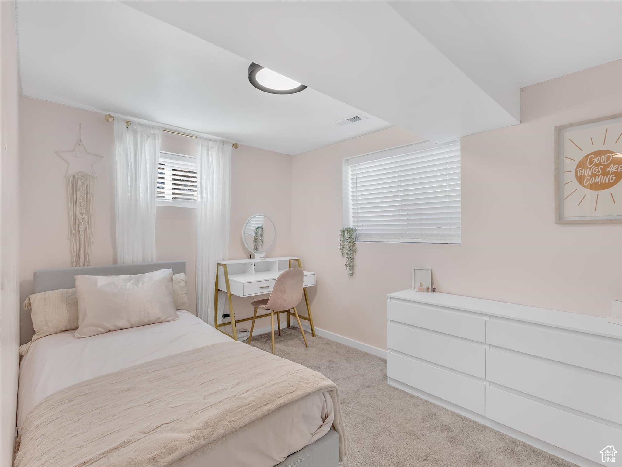 Bedroom featuring light carpet, baseboards, and visible vents