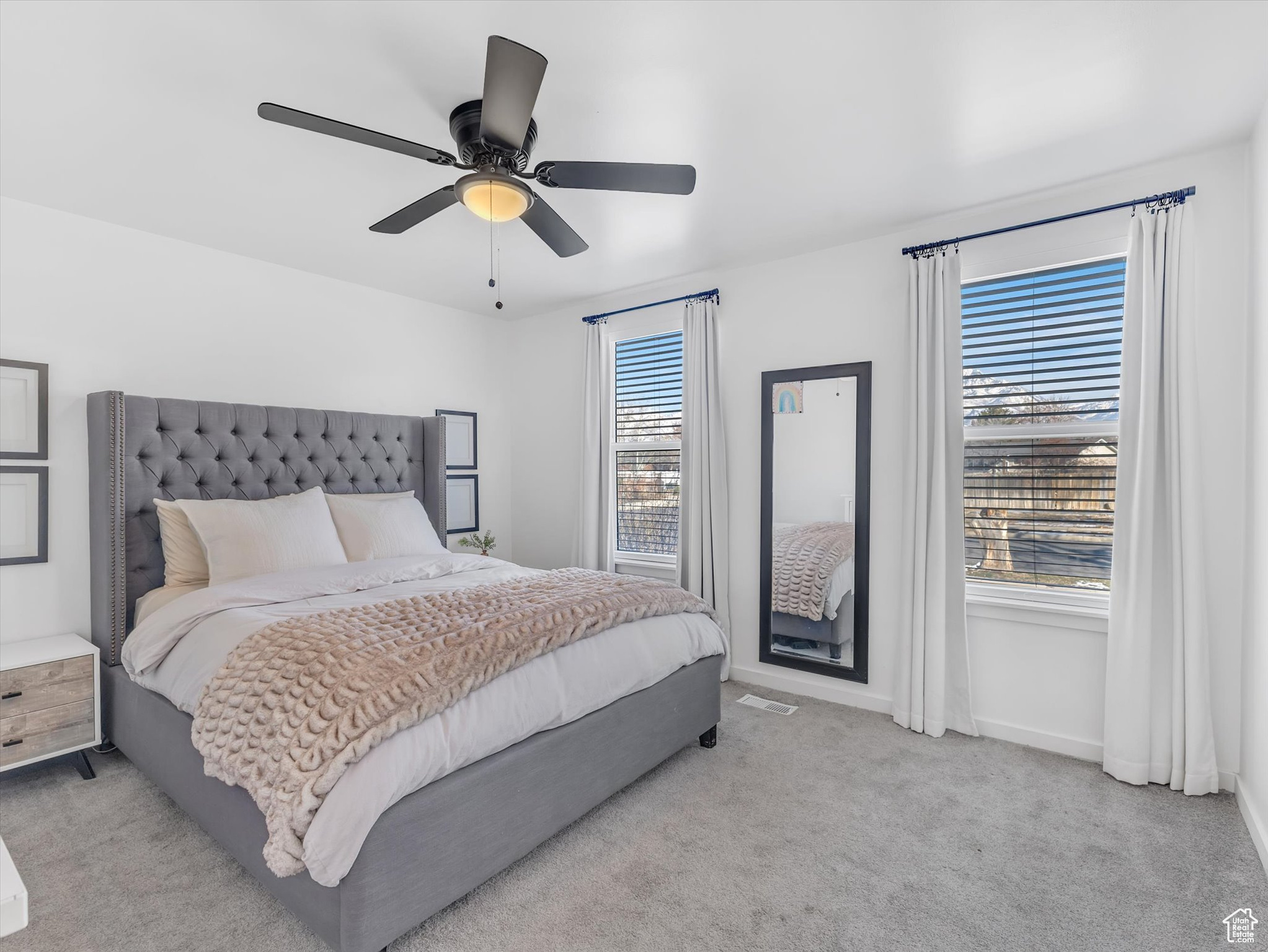 Bedroom with baseboards, ceiling fan, and light colored carpet