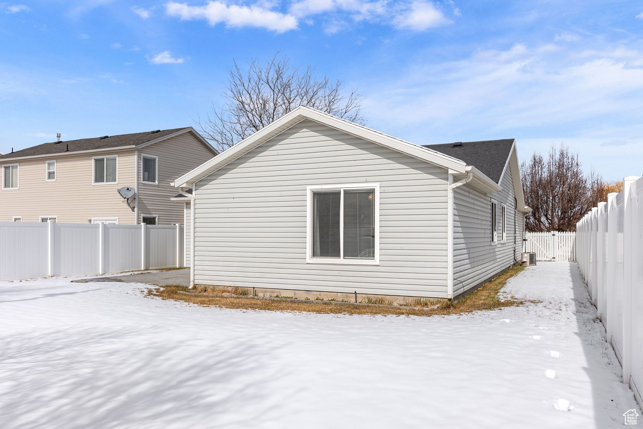 Snow covered house featuring a fenced backyard