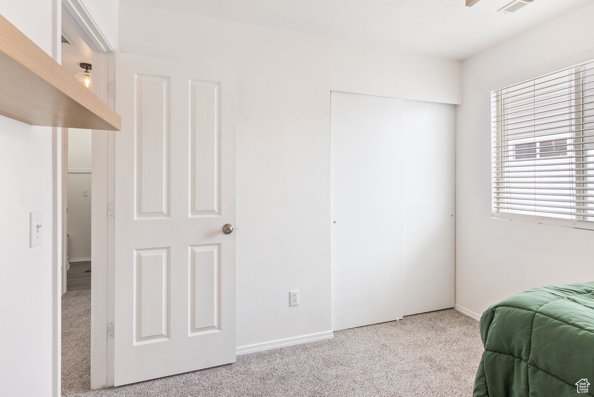Bedroom featuring baseboards, a closet, visible vents, and light colored carpet