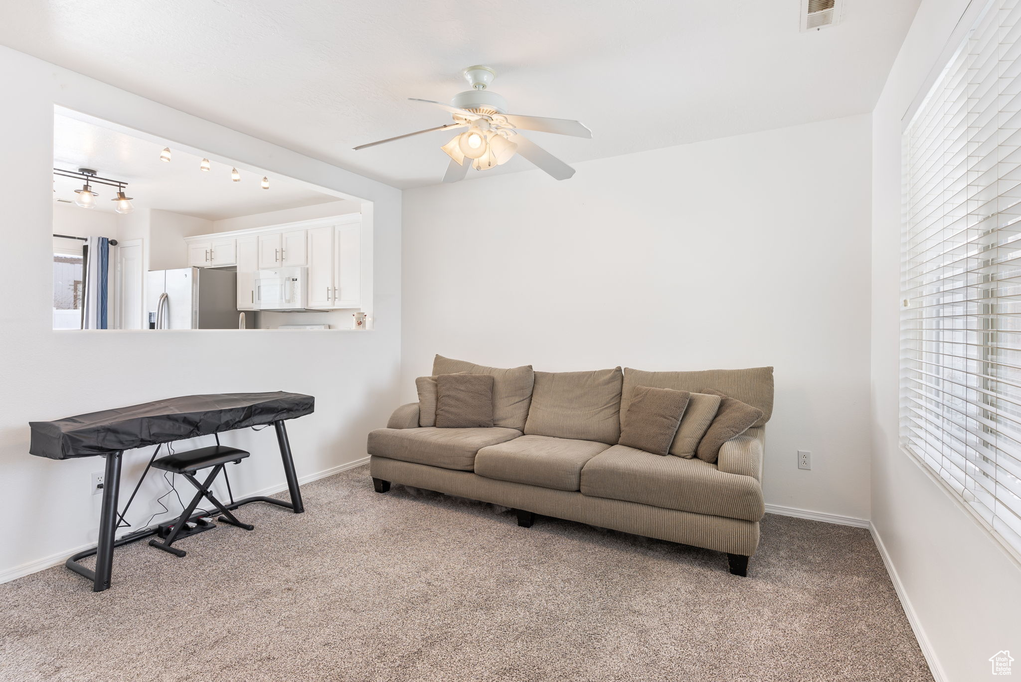 Living room featuring light carpet, visible vents, a wealth of natural light, and baseboards