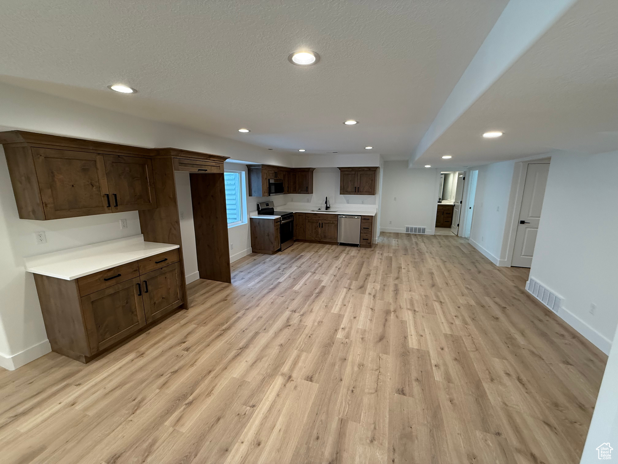 Kitchen featuring light countertops, light wood-style floors, visible vents, and appliances with stainless steel finishes