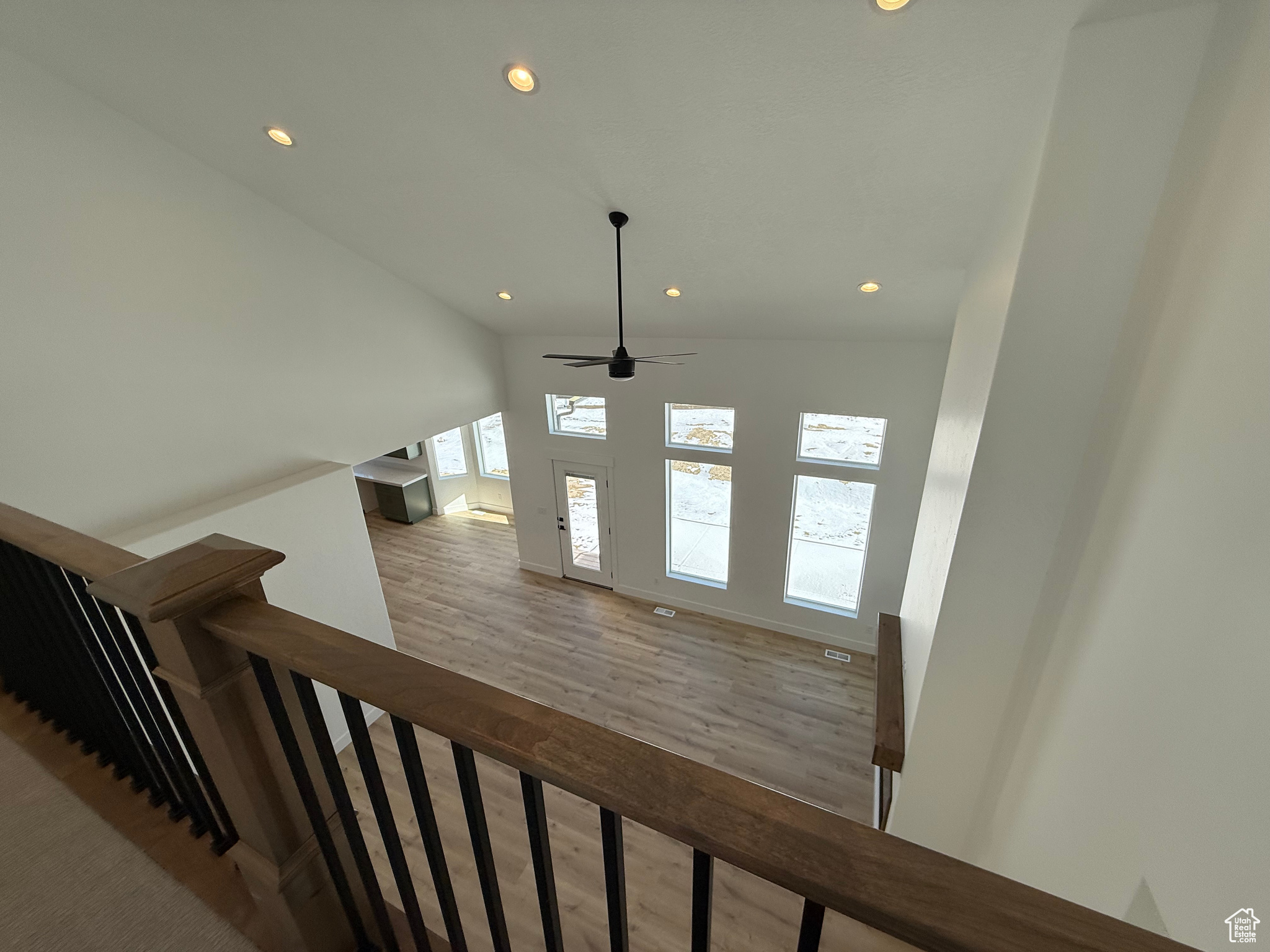 Staircase with wood finished floors and recessed lighting