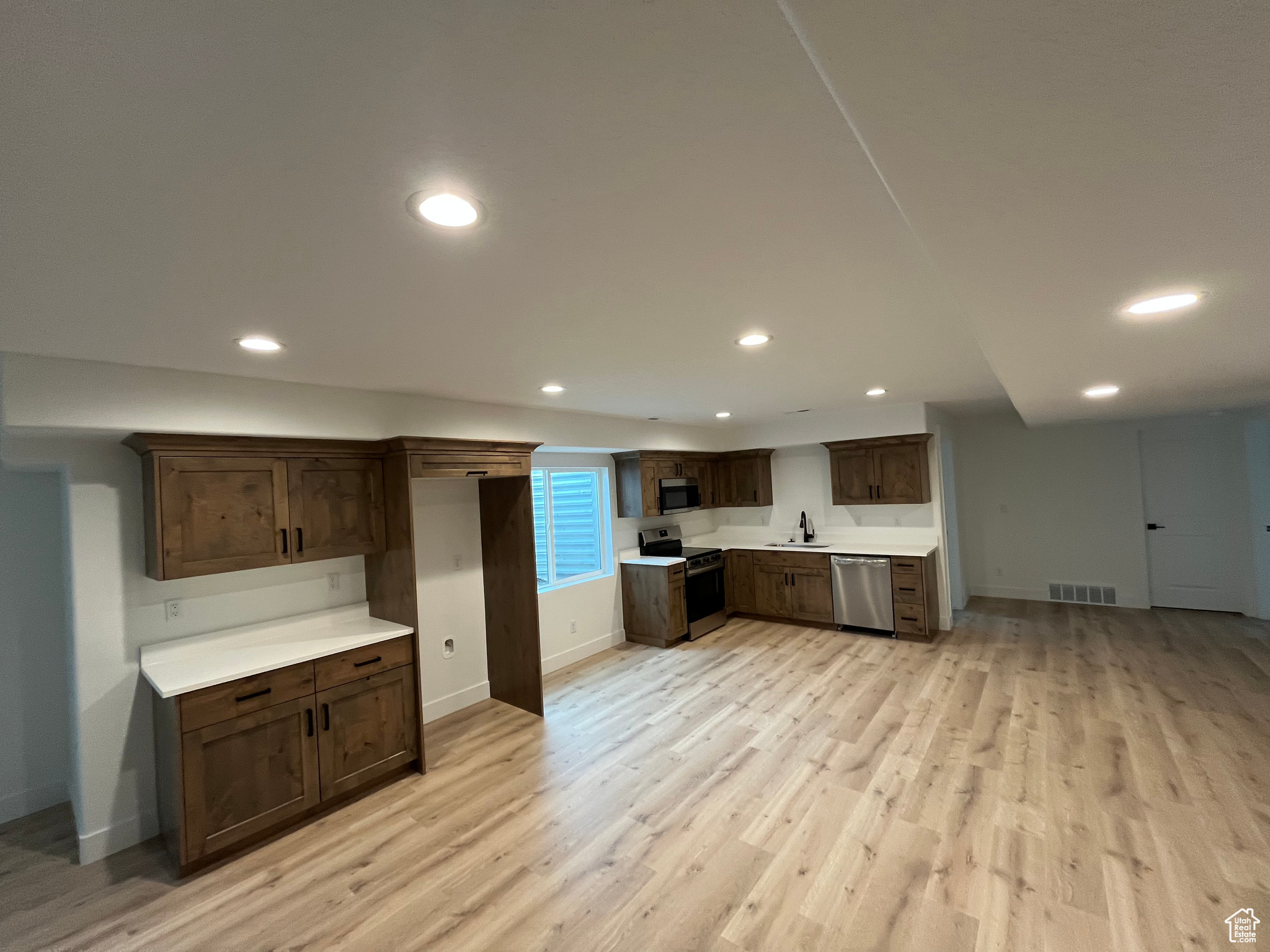 Kitchen featuring recessed lighting, stainless steel appliances, visible vents, light countertops, and light wood finished floors