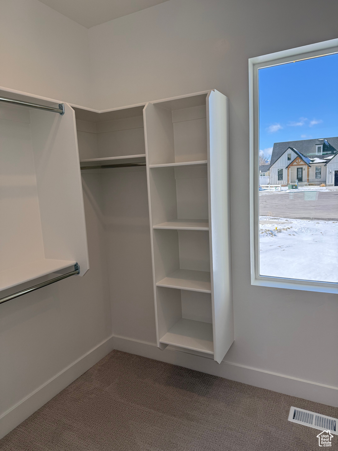 Spacious closet with carpet floors and visible vents