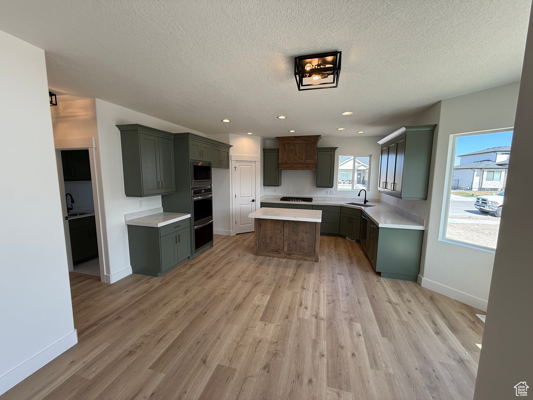 Kitchen with stainless steel appliances, light wood-type flooring, and a sink