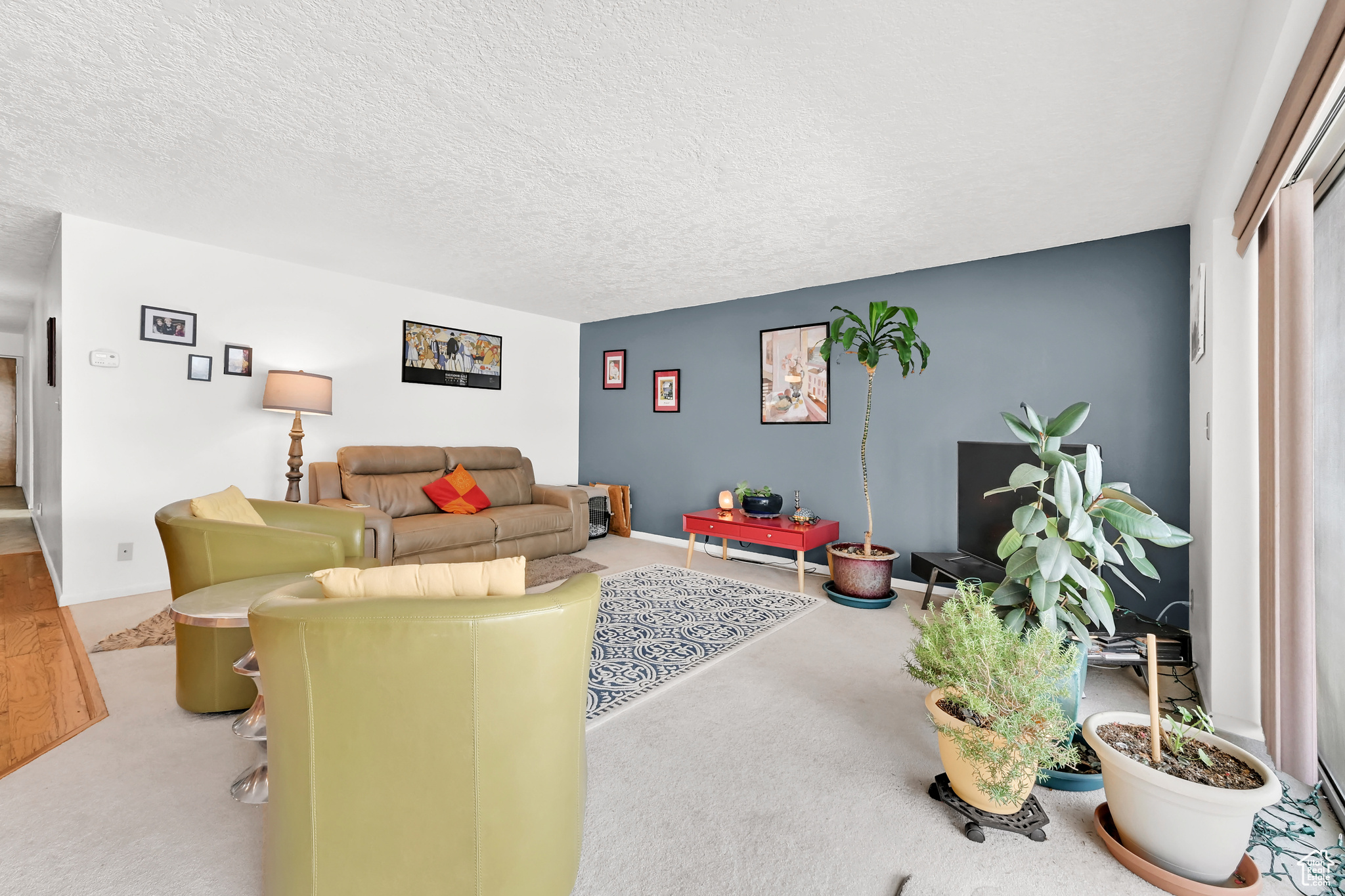 Living room with a textured ceiling and light colored carpet