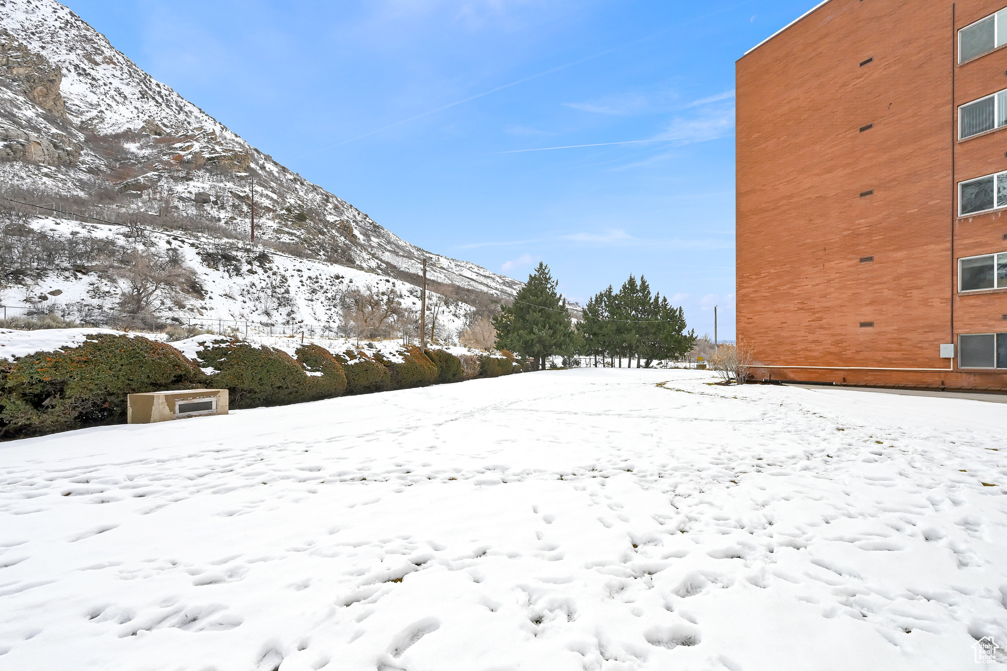 Yard covered in snow featuring a mountain view